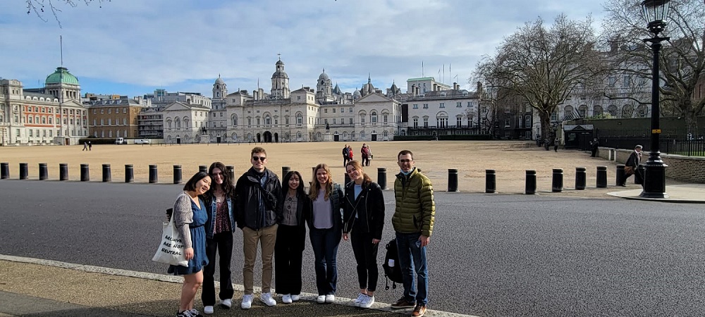 A group of students and professors standing in front of a buliding